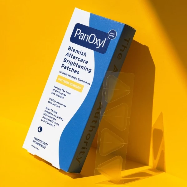 PanOxyl Blemish Aftercare Brightening Patches package leaning on a yellow background.