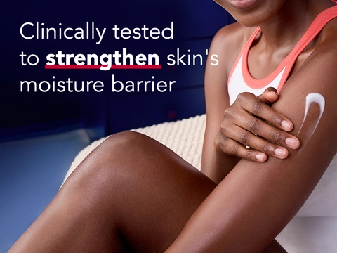 Woman with deeper skin tone applying Aquaphor cream to shoulder on dark blue background, with text reading Clinically tested to strengthen skin's moisture barrier