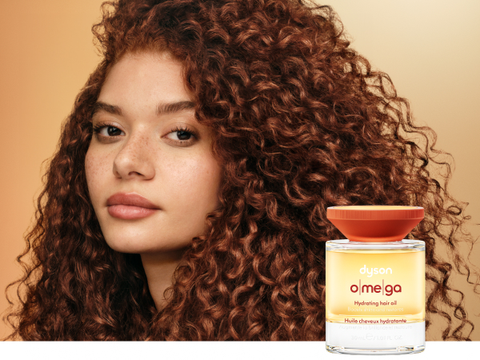 Curly hair model shows off her nourished hair after using Dyson Omega products.