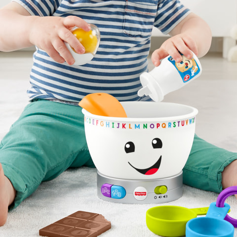 Shake up the egg rattle, pour out some milk, and take a "bite" of the chocolate bar teether