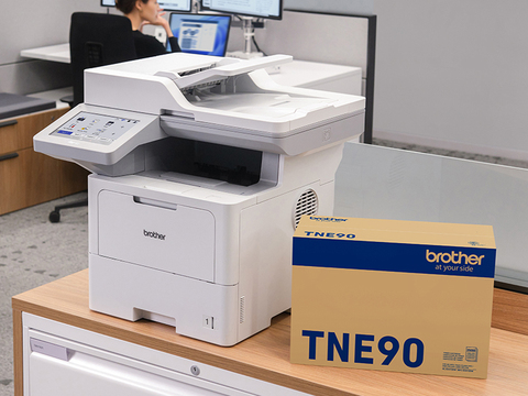 Brother MFCEX915DW Enterprise monochrome laser all-in-one printer on shelf in corporate office shared printing station, shown with Brother Genuine TNE90 max yield replacement toner