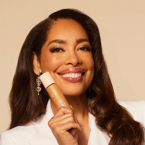 Gina Torres holding Halo Glow Liquid Filter in hand