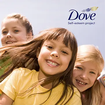 A picture of three light-skinned children grouped side by side, smiling at the camera