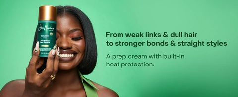 SheaMoisture Silk Press cream held by a woman with dark skin against a green backdrop. Text reads: "From weak links &amp; dull hair to stronger bonds &amp; straight styles. A prep cream with built-in heat protection."