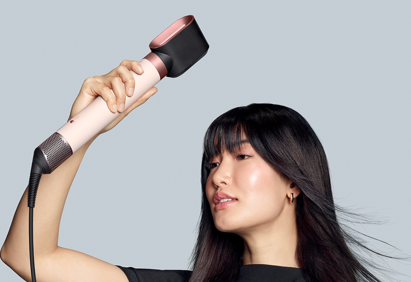 The Dyson Airwrap Co-anda2x multi-styler and dryer with the Fast dryer 2x used by a dark-haired model to dry her long hair.
