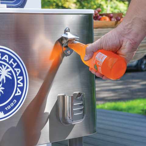 Glass bottle being opened on front of cooler.