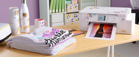 Sublimation machine on a table, with printed output, shirts & other projects