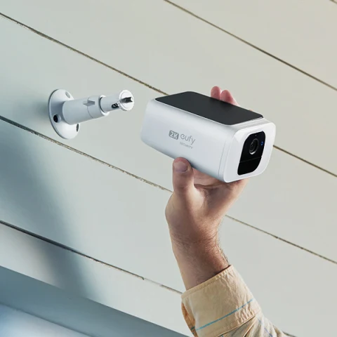 Simple, seamless installation depicted with hand placing SoloCam S230 onto home wall.