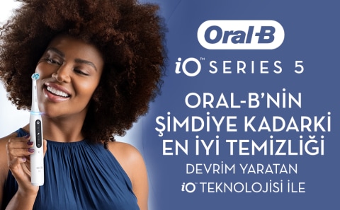 iO teknolojisine sahip Oral-B iO Series 5’i tutarak gülümseyen kadın.