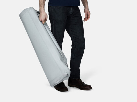 Man holding a folded and deflated Enventur Travel Kennel