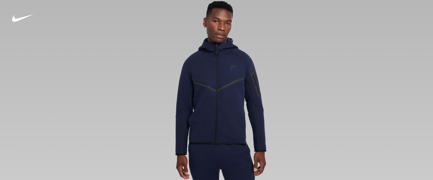 Guy wears a Nike Tech full-zip hoodie, showcasing sleek design with contrasting panel details.