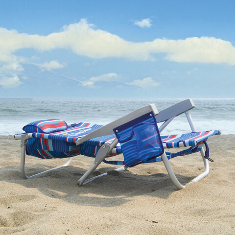 Beach chair lying flat on the beach.