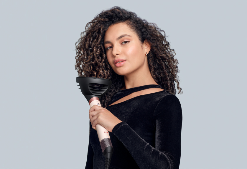 Model using Dyson Airwrap Co-anda2x with the Wave+Curl diffuser 2x in Dome mode