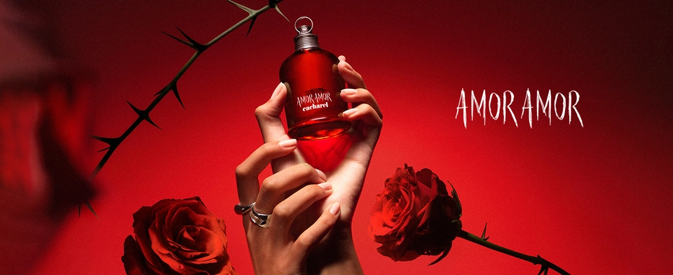 Mão segurando um frasco de amor amor sob fundo vermelho com rosas vermelhas ao redor