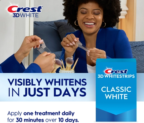 Reflection of woman in mirror smiling and peeling a Crest 3DWhitestrip. Visibly whitens in just days.