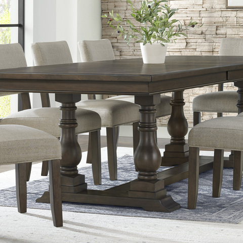 Close-up of the end of the dining table showing turned wood pillar base structure in a lifestyle scene.