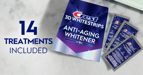 14 Treatments Included. Pack of Crest 3DWhitestrips Anti-Aging Whitener next to 3 sachets on a marble counter.