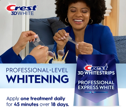 Reflection of woman in mirror smiling and peeling a Crest 3DWhitestrip. Professional-Level Whitening.