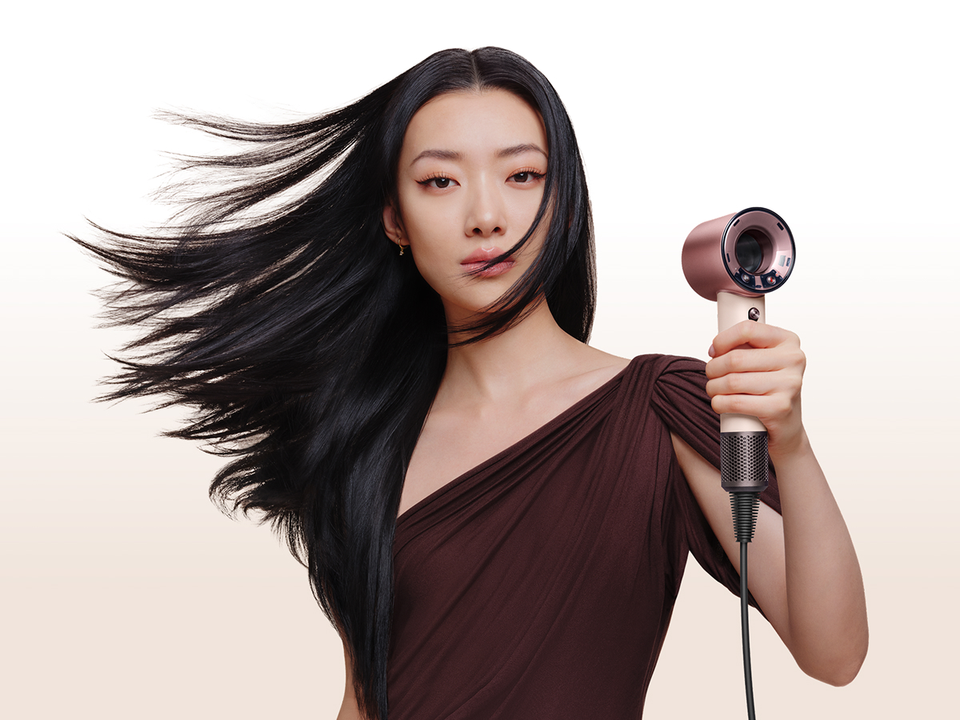 Model with smooth, styled hair after using the Dyson Supersonic Travel hair dryer.