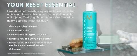 Moroccanoil Clarifying Shampoo bottle with foam on glass shelf, highlighting gentle purifying formula that removes buildup and pollutants for clean, color-safe hair.
