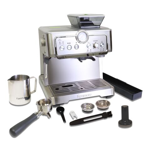 Kenmore semi-automatic espresso maker and all included accessories (milk frothing jug, portafilter, coffee scoop, steam nozzle cleaning pin, cleaning brush, 1- and 2-cup double-wall filter baskets, tamper, and accessory tray) on a white background. Text above reads, &quot;All accessories included.&quot;