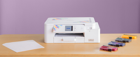 Sublimation printer on a table with paper and inks.