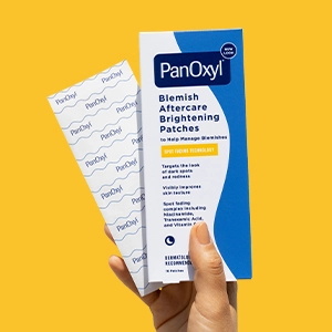 A hand holding a box of Blemish Aftercare Brightening Patches and a strip of patches