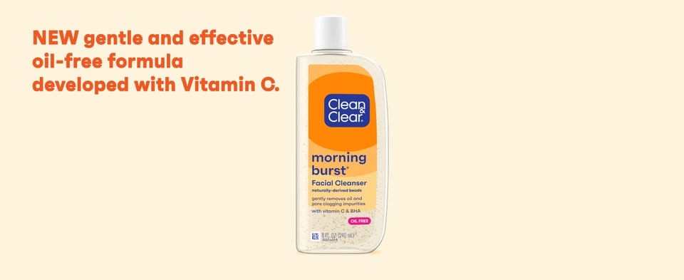 Bottle of Clean &amp; Clear Morning Burst Facial Cleanser on orange background