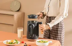 Image showing a person opening the lid of the nut milk maker.