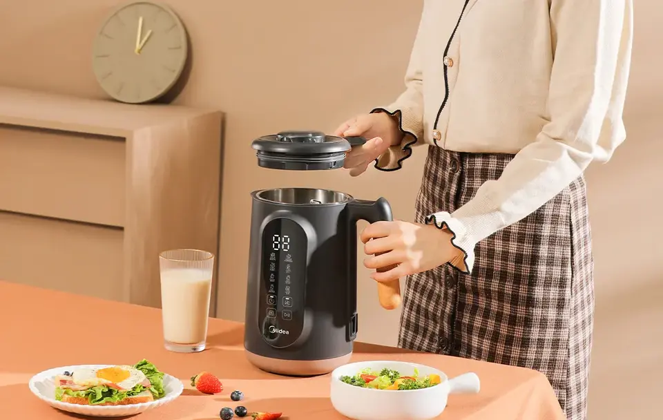 Image showing a person opening the lid of the nut milk maker.