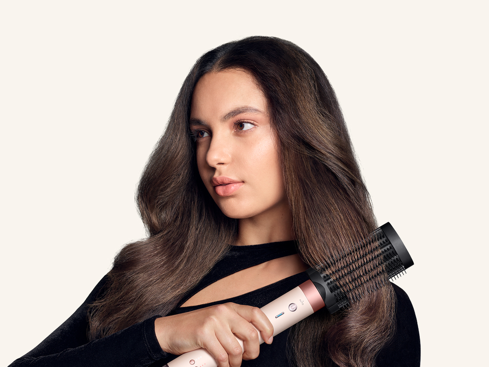 Model brushes her hair with the Dyson Anti-snag loop brush 2x.