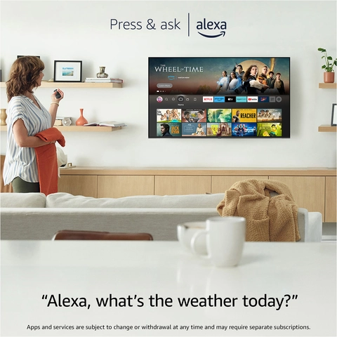 woman standing in front of living room tv pressing her remote and asking it what the weather is