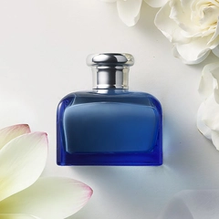 Ralph Lauren Blue fragrance bottle surrounded by key ingredients Lotus Flower, Gardenia, and Musk.