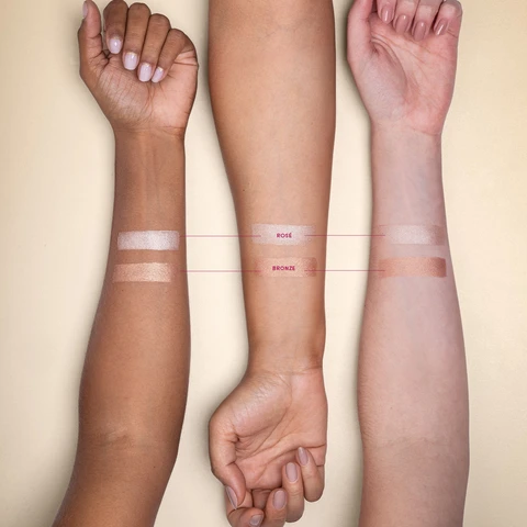 Imagem com três braços dispostos um ao lado do outro, sendo de diferentes tons de pele. Temos a aplicação das duas cores do Iluminador Luminous.