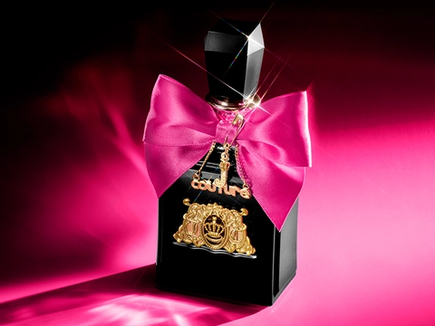 Juicy Couture Viva La Juicy Elixir perfume bottle on a pink and black background