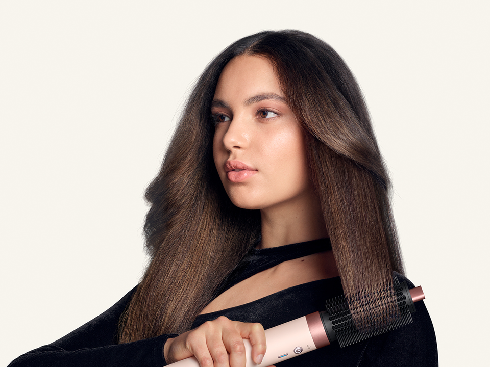 Model styles her hair with the Dyson Large round volumizing brush 2x.
