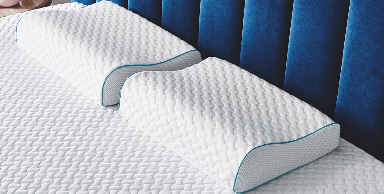 Image: Two contour pillows with covers on mattress topper with cover - both with raised edge facing.