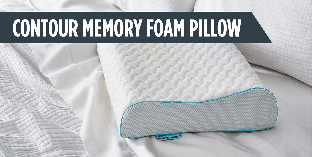 Text: Contour Memory Foam Pillow. Image: Contour pillow with cover lays on bed with white sheets.